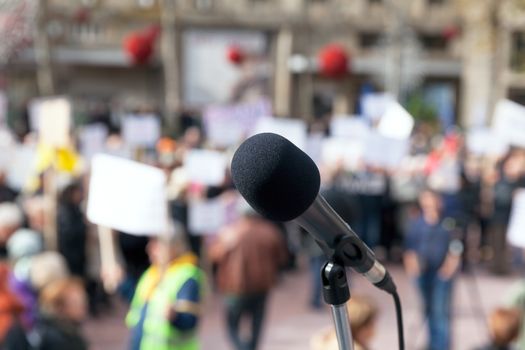 Microphone in focus against blurred protesters