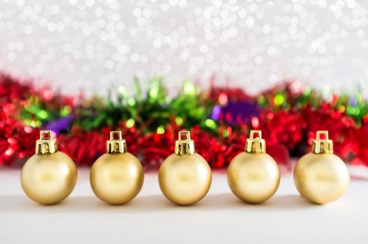Golden balls and Christmas decorations with lights snow winter background. Space for copy.