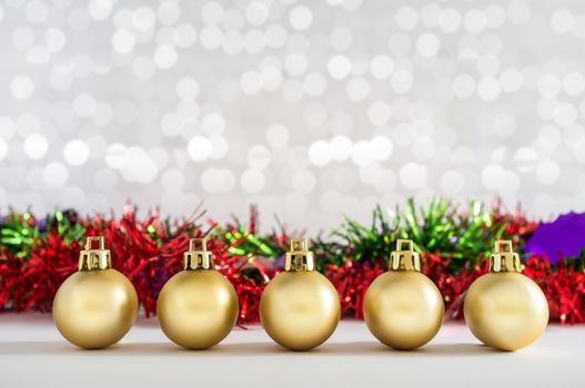 Golden balls and Christmas decorations with lights snow winter background. Space for copy.