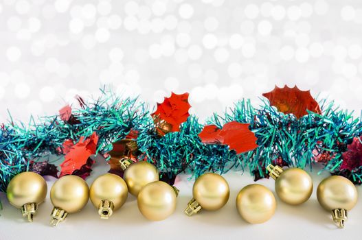 Golden balls and Christmas decorations with lights snow winter background. Space for copy.