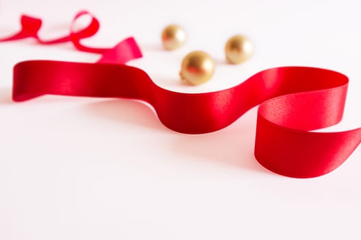Golden christmas balls with red ribbon on white background.