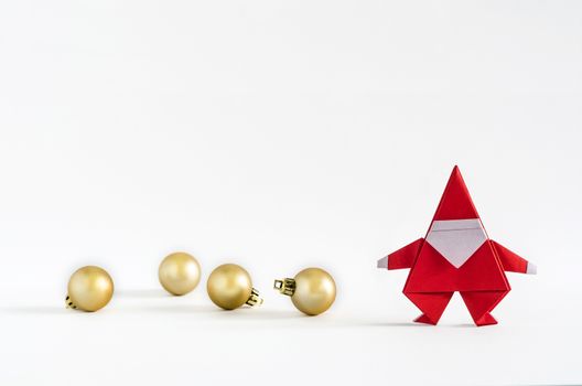 Santa Claus paper craft and golden ball on white background. Paper origami.