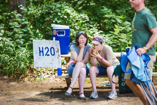 HOT SPRINGS, NC - JULY 9: Pair of female friends at a water hydration station on table at the wild Goose Festival on July 9, 2016 in Hot Springs, NC, USA.
