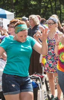 HOT SPRINGS, NC - JULY 10: Joyful young adult woman praising God at the Wild Goose Festival on July 10, 2016 in Hot Springs, NC, USA.