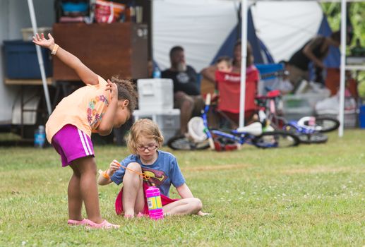 HOT SPRINGS, NC - JULY 7: Two little girls playing and blowing bubbles at the Wild Goose Festival on July 7, 2016 in Hot Springs, NC, USA.