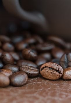 Close up roasted coffee beans and coffee cup