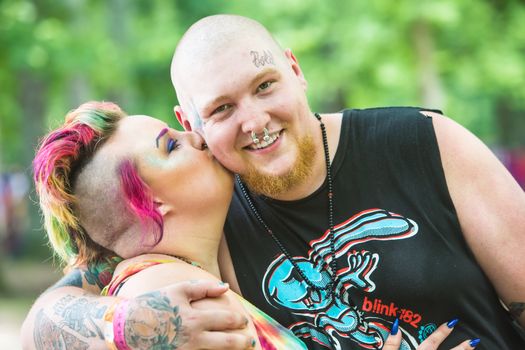 HOT SPRINGS, NC - JULY 8: Happy young adult couple kissing outdoors at the Wild Goose Festival on July 8, 2016 in Hot Springs, NC, USA.