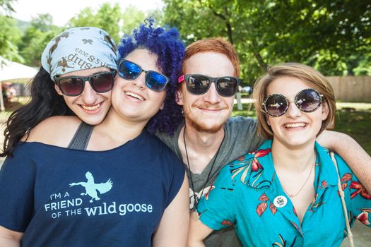HOT SPRINGS, NC - JULY 9: Four male and female friends hugging each other at the wild Goose Festival on July 9, 2016 in Hot Springs, NC, USA.