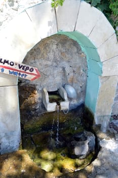 Old stone fountain in the campaign on the Cretan