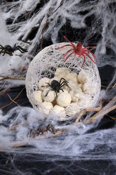 candy waffle balls in the form of spider eggs in a cocoon with a spider on the table for Halloween