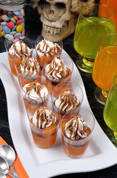 portioned dessert of pumpkin with whipped cream and chocolate topping on Halloween