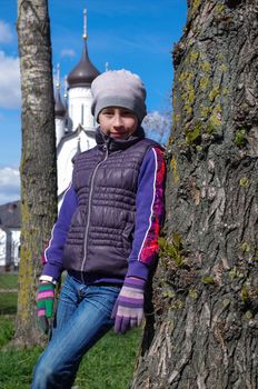 Teenager girl standing between two trunk in a park