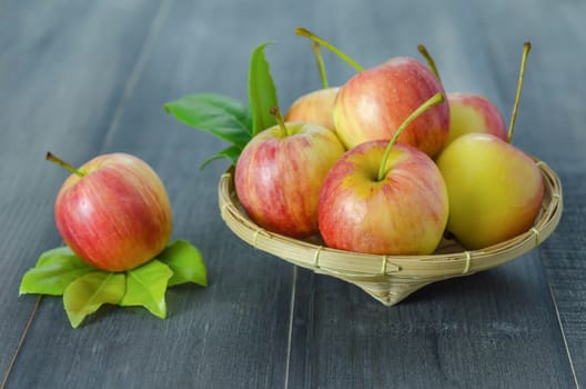 Red and yellow apple  with bamboo basket , organic fresh fruit on wooden background