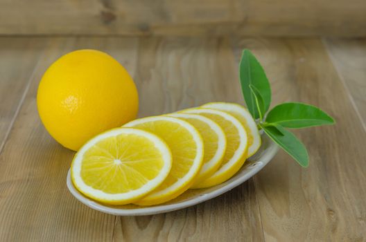 slice orange on dish over wooden background