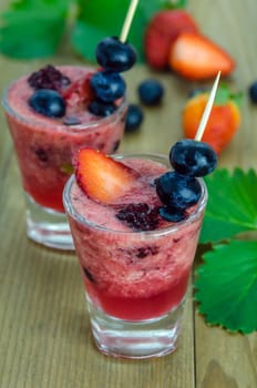 Raspberry smoothie with fresh berries on a wooden table