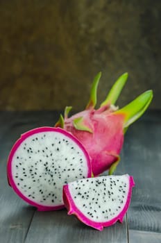 Ripe Dragon fruit or Pitaya with slice on wooden background , still life