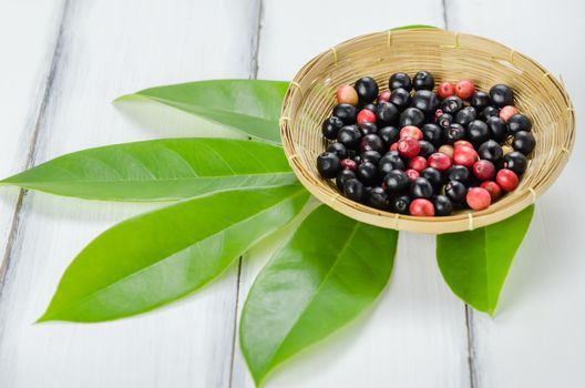 Thai Blueberry in bamboo basket over wooden background , still life
