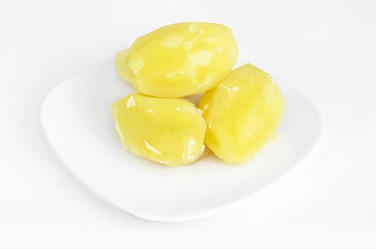 Boiled potatoes on a plate, white background.
