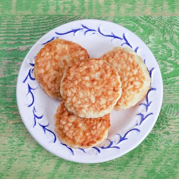 Rice patties in a plate on old wooden background.