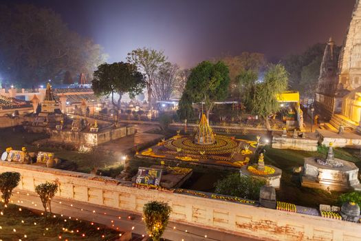The place of an enlightenment of Buddha, Mahabodhi Temple and stupas in beams of night illumination and in festive decoration in honor of a menlam and celebration of Buddhist new year.