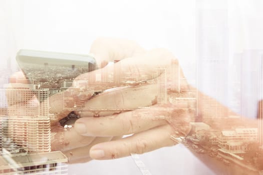 Double exposure of man using smart phone and cityscape background ,Business technology concept.