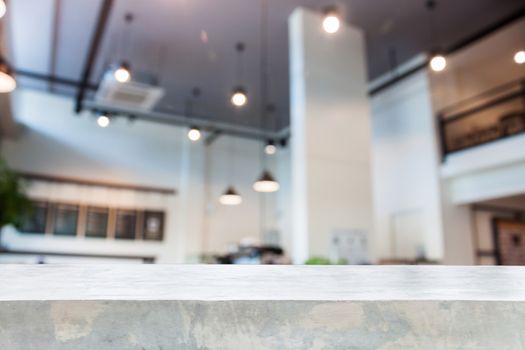 Concrete table top with abstract blur coffee shop interior for background