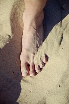 Vacation holidays. Feet closeup on beach on sunbed enjoying sun on sunny summer day.