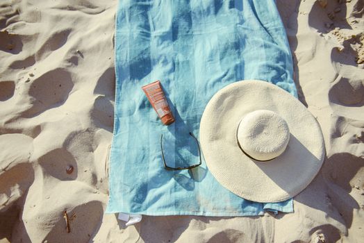 beach background with hat, towel and glasses