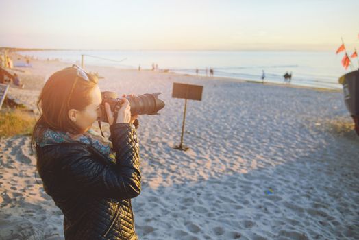 professional woman photographer on the beach, summer time