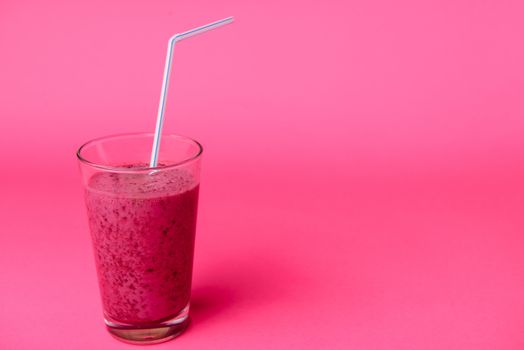 Blueberry smoothie with fresh berries, chia seeds and banana for breakfast on pink background, selective focus