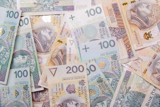 Polish zloty in notes and coins on red background