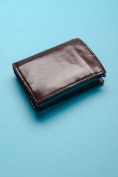 brown mans leather wallet on a blue background