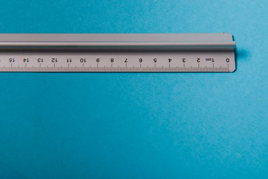 aluminum ruler on blue background. High resolution