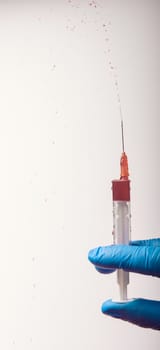 Hand in glove with syringe on white background. Injections.