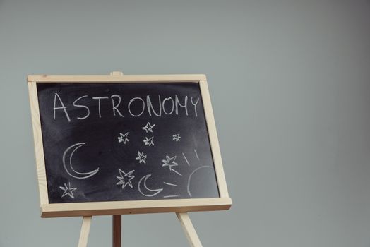 Woman draw on chalkboard astronomy subject. Gray background