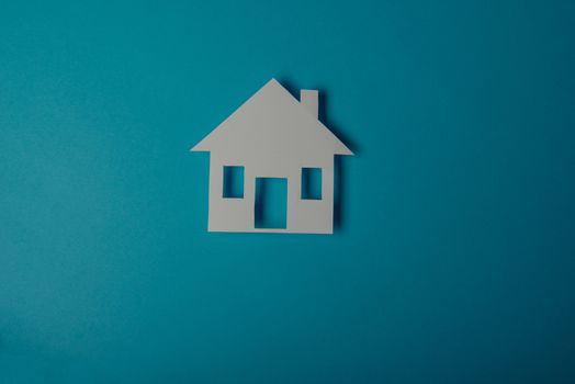 House shaped paper cutout on on blue background
