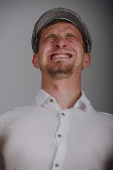 young man with a strong pain against gray background