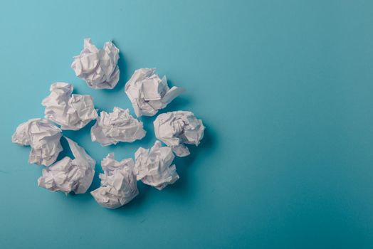 crumpled paper ball isolated on a blue background