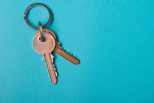 silver house key lying on blue paper background