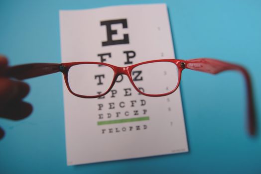 close up view of glasses lying on snellen test chart