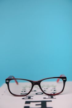 close up view of glasses lying on snellen test chart