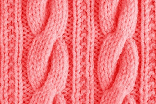 Sweater or scarf texture large knitting. Knitted jersey background with a relief pattern. Braids in knitting. Wool hand-knitted or machine knitting pattern. Fabric Background.