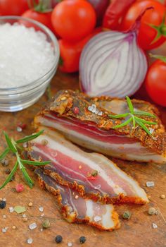 Traditional bacon with vegetables on wooden table