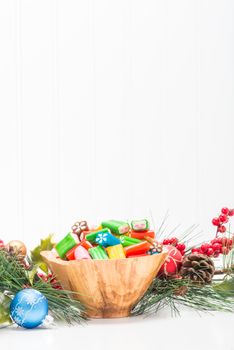 Colorful candies in a bowl with a seasonal festive background.
