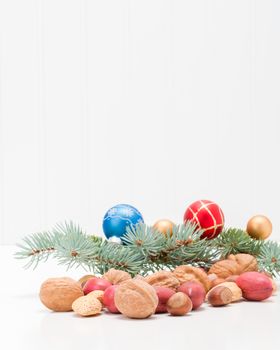Variety of whole mixed nuts as part of a festive holiday scene.