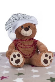 Teddy bear with silver Christmas hat and red necklace, isolated