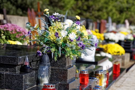 bouquet of flowers and candles on cemetery