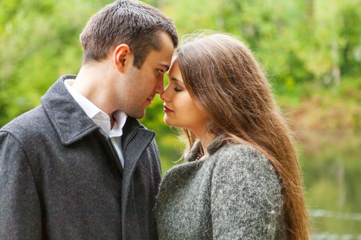 sad young couple in autumn park together faces close