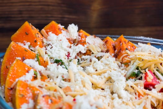 Vegetarian salad of orange pumkin, mixed vegetables, herbs and cheese