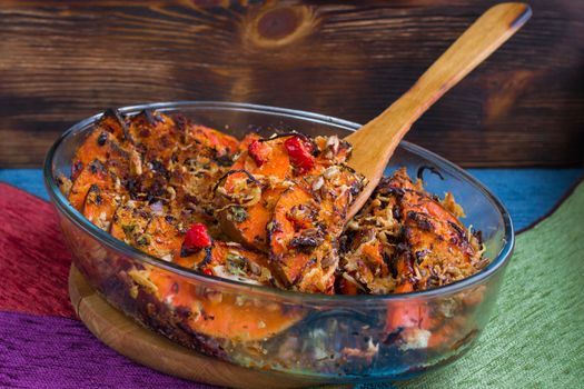 Vegetarian dish of orange pumkin, mixed vegetables, herbs and cheese baked in oven